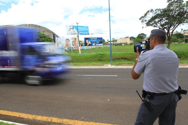 Policial militar maneja aparelho em avenida da cidade